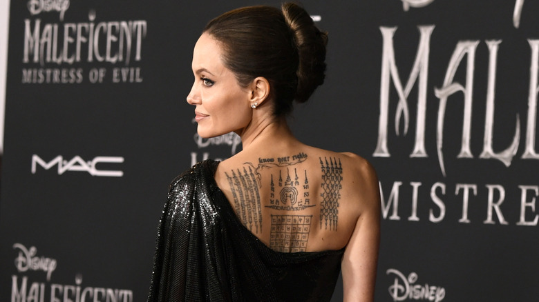 Angelina Jolie back tattoos showing Yantra sacred script at Cambodia premiere 2017